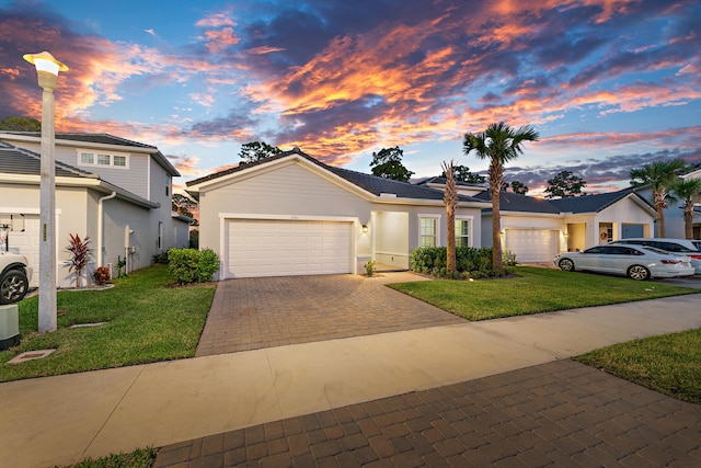 view of front of home with a garage and a yard