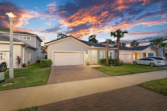 200 SW Pomeroy St, Stuart, FL 34997 - view of front facade with an attached garage, a front lawn, decorative driveway, and stucco siding