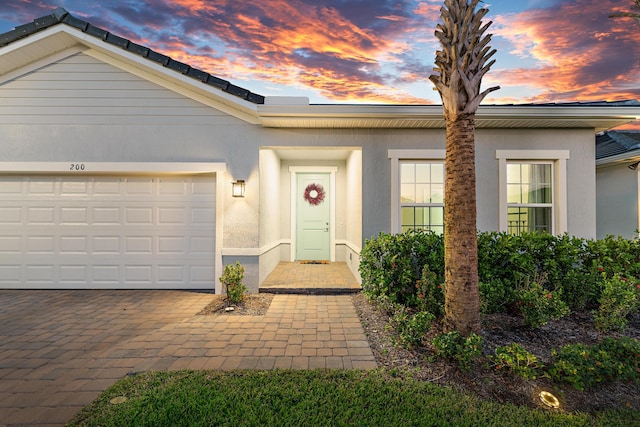 200 SW Pomeroy St, Stuart, FL 34997 - view of front of house with stucco siding, an attached garage, and driveway
