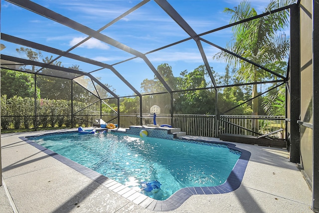 view of pool featuring glass enclosure and a patio area