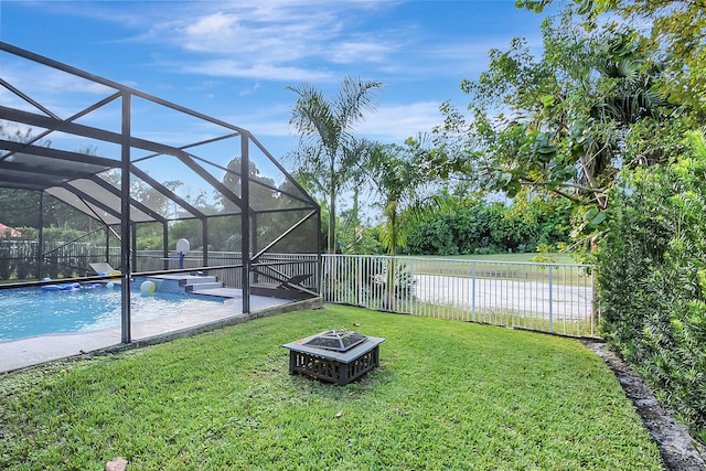 view of yard featuring a fenced in pool, a patio area, an outdoor fire pit, and a lanai