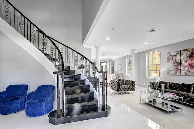 stairs with tile patterned floors, crown molding, and decorative columns