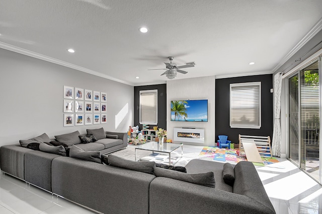 living room with ceiling fan, a textured ceiling, light tile patterned floors, and crown molding