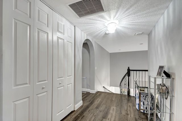 hallway with hardwood / wood-style flooring and a textured ceiling