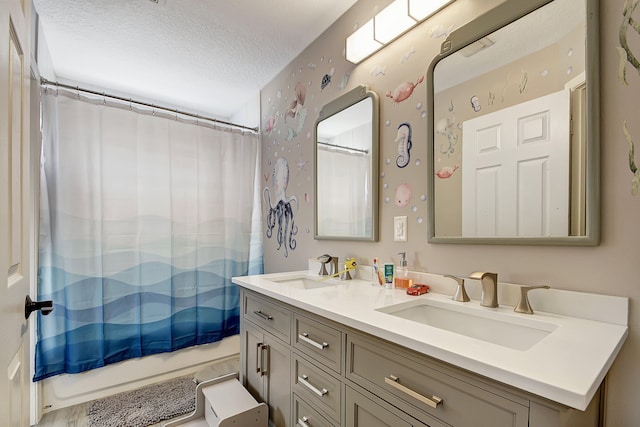 bathroom featuring vanity, a textured ceiling, and shower / bathtub combination with curtain