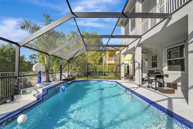 view of pool with a lanai, grilling area, ceiling fan, and a patio