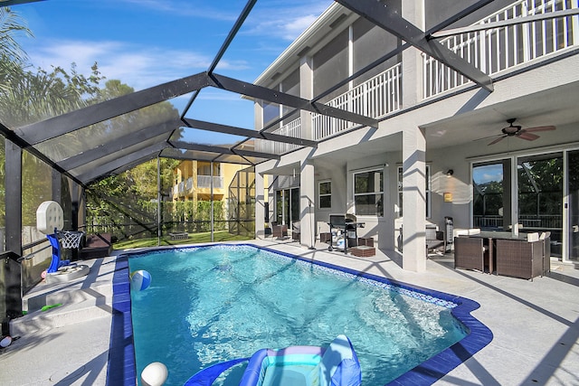 view of pool with ceiling fan, a lanai, and a patio