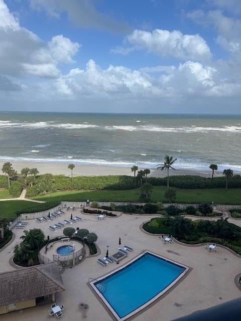 view of pool featuring a beach view and a water view