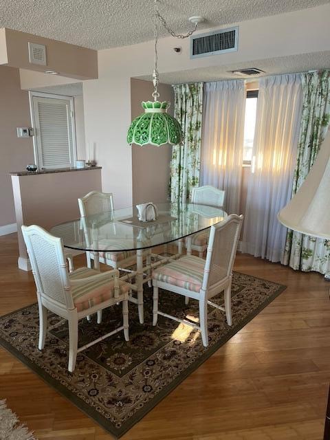 dining space featuring hardwood / wood-style floors and a textured ceiling