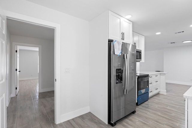 kitchen with white cabinetry, appliances with stainless steel finishes, and light wood-type flooring