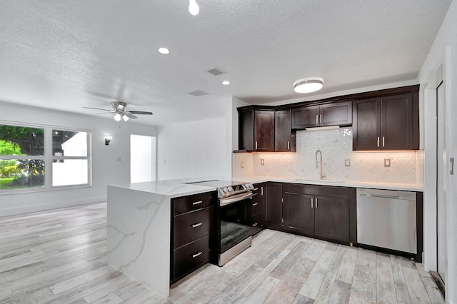 kitchen featuring light hardwood / wood-style floors, stainless steel appliances, kitchen peninsula, sink, and ceiling fan