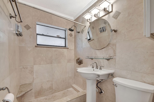 bathroom featuring tile walls, tiled shower, toilet, and crown molding