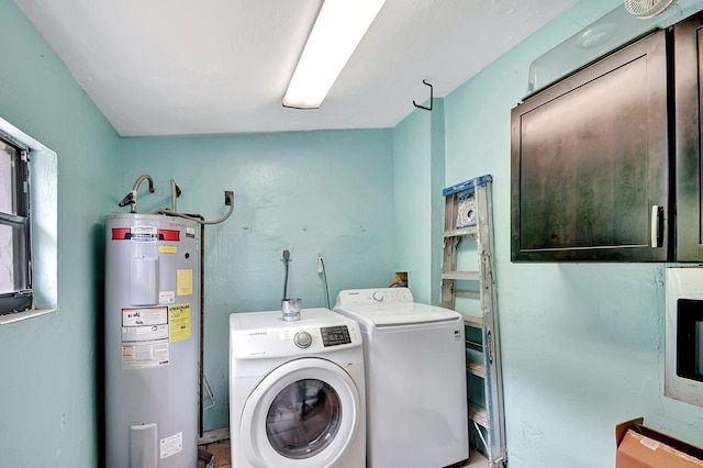 clothes washing area featuring electric water heater and washer and dryer