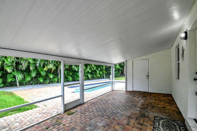 unfurnished sunroom featuring vaulted ceiling