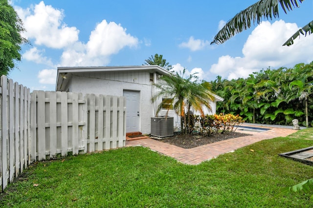 view of yard with cooling unit and a pool