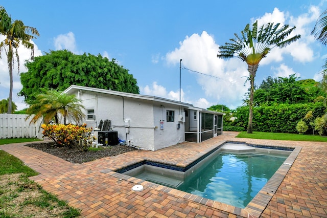 view of pool with a sunroom and a patio area