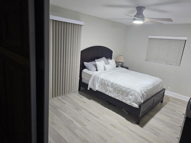 bedroom with light wood finished floors, ceiling fan, and baseboards