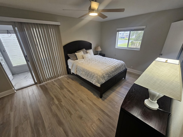 bedroom featuring baseboards, wood finished floors, a ceiling fan, and access to exterior