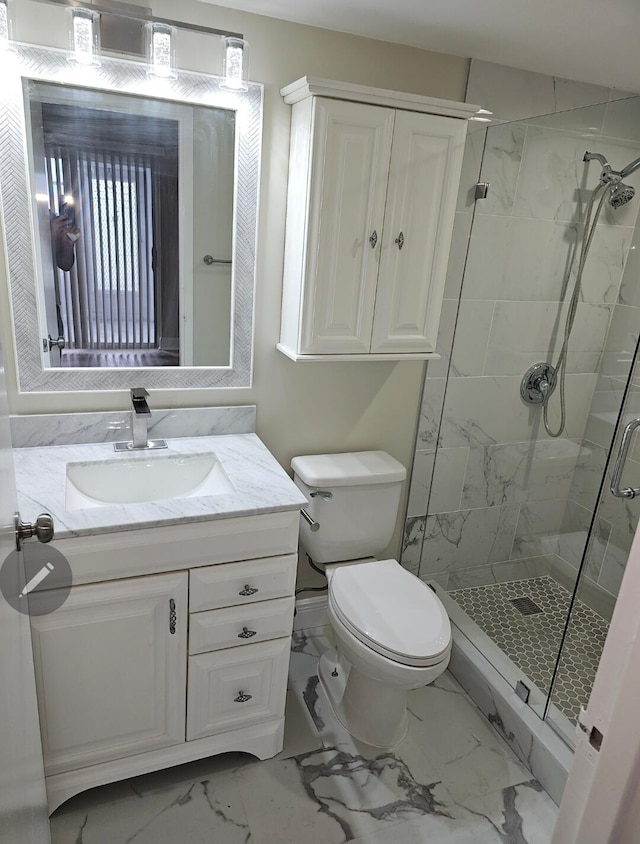 bathroom with toilet, marble finish floor, vanity, and a stall shower