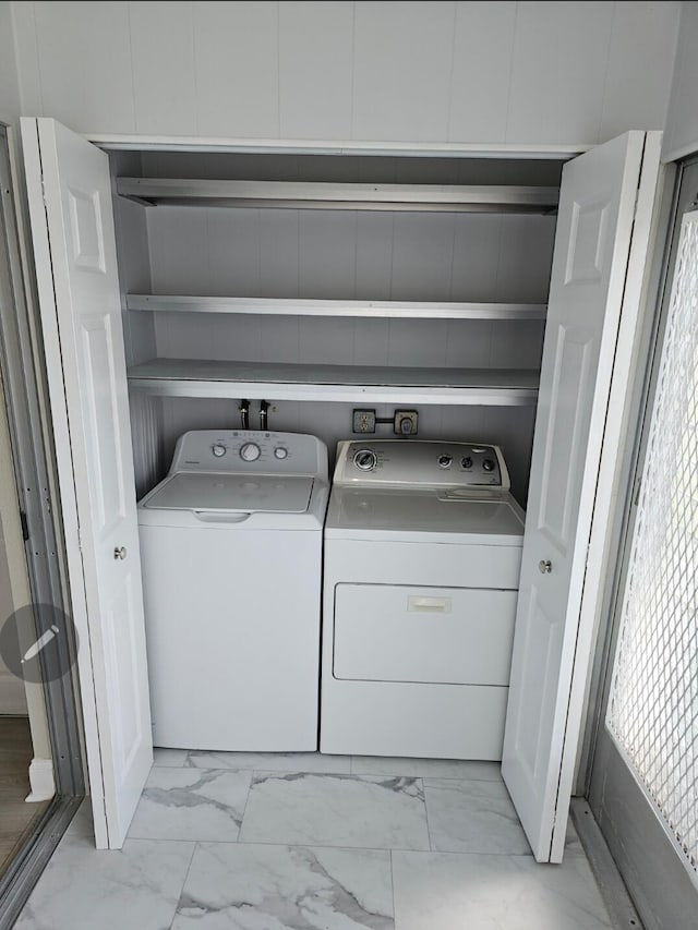 laundry room featuring marble finish floor, washer and clothes dryer, and laundry area