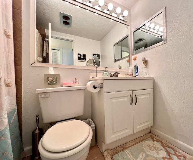 bathroom featuring vanity, tile patterned floors, a textured ceiling, and toilet