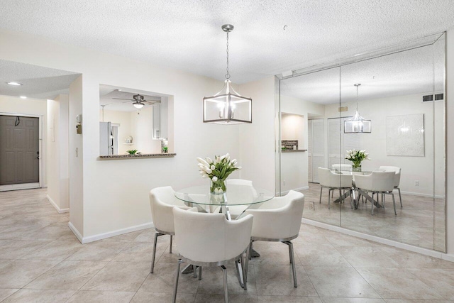 dining space featuring a textured ceiling, ceiling fan, and light tile patterned flooring