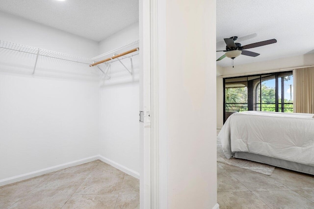 bedroom featuring light tile patterned flooring, ceiling fan, and a textured ceiling