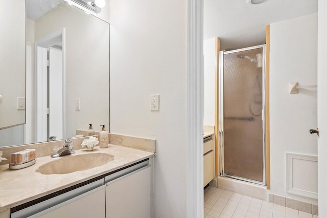 bathroom with vanity, walk in shower, and tile patterned flooring