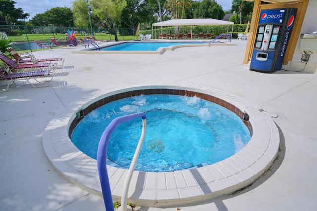 view of swimming pool with a community hot tub and a patio area