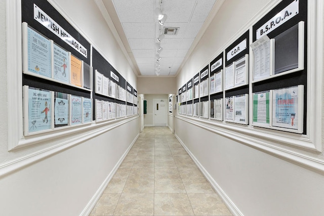 hallway with a healthy amount of sunlight, track lighting, and light tile patterned floors