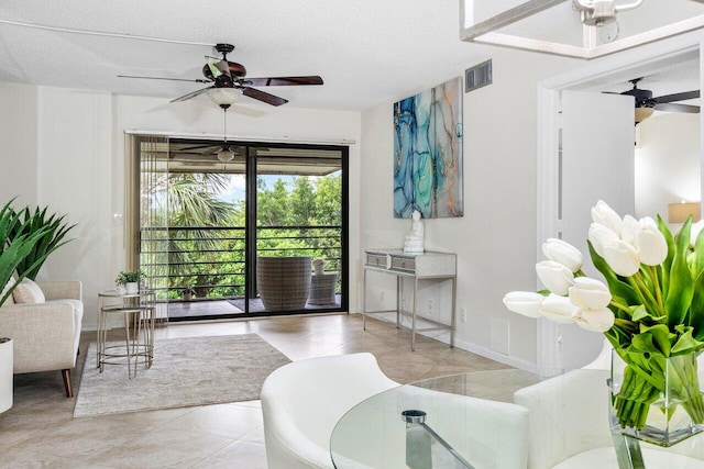 tiled living room featuring a textured ceiling and ceiling fan