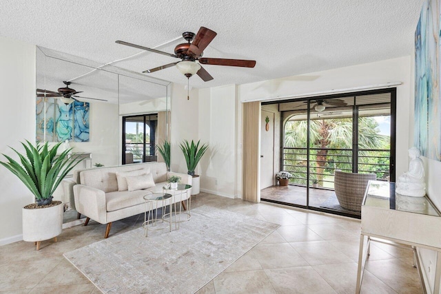 living room featuring ceiling fan, a textured ceiling, and light tile patterned floors