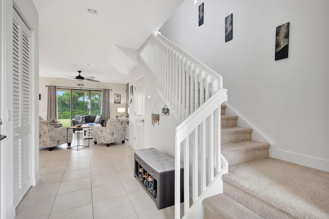 stairway featuring ceiling fan and tile patterned flooring