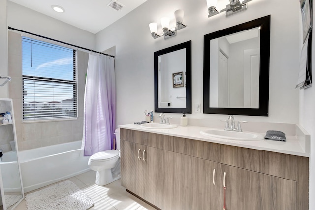 full bathroom featuring vanity, shower / bath combo with shower curtain, tile patterned floors, and toilet