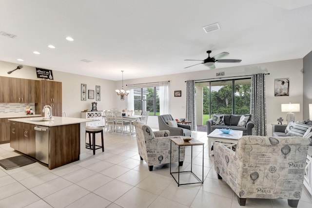 tiled living room with ceiling fan with notable chandelier and sink