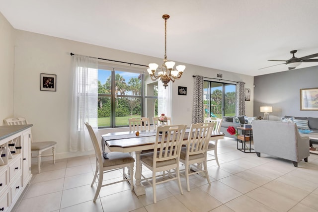 tiled dining space with a wealth of natural light and ceiling fan with notable chandelier