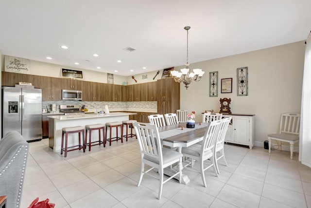 tiled dining area featuring an inviting chandelier