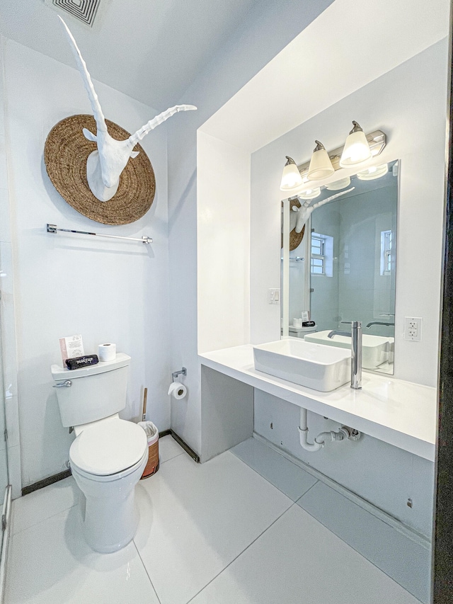 bathroom featuring toilet, vanity, and tile patterned floors