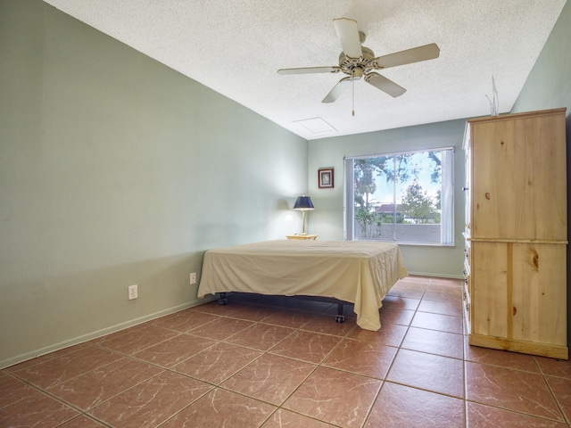 unfurnished bedroom with a textured ceiling, tile patterned floors, and ceiling fan