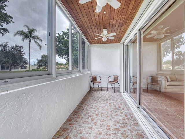 unfurnished sunroom with wooden ceiling and ceiling fan