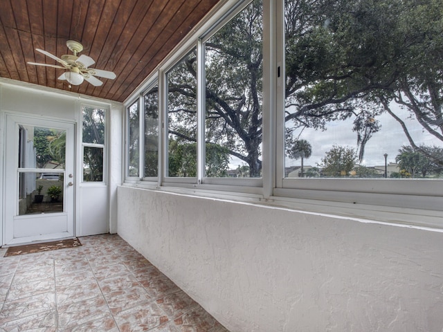 unfurnished sunroom with wooden ceiling and ceiling fan