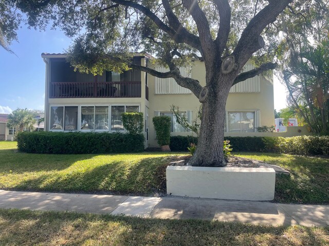 view of front facade with a balcony and a front yard