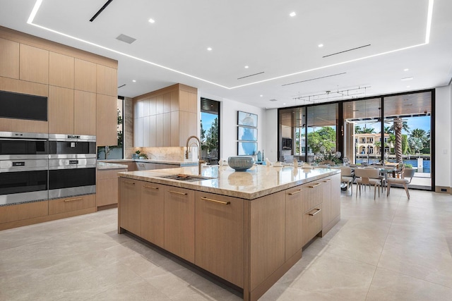 1520 Royal Palm Way, Boca Raton, FL 33432 - kitchen featuring modern cabinets, light brown cabinets, a spacious island, a sink, and expansive windows