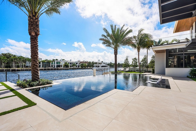 view of swimming pool featuring a water view and a patio