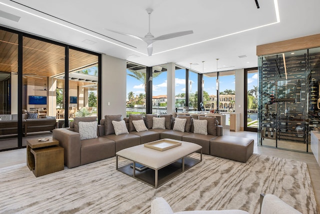 living room featuring expansive windows, ceiling fan, and plenty of natural light