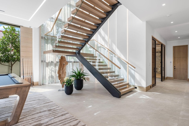 stairway featuring billiards and concrete flooring