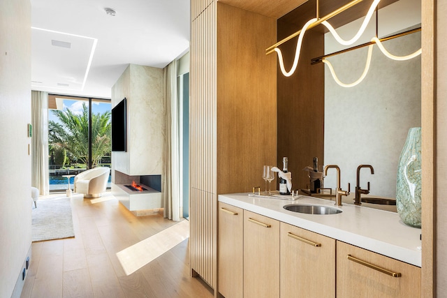 bathroom with walk in shower, expansive windows, vanity, and hardwood / wood-style flooring