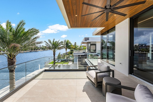 balcony featuring a water view and ceiling fan