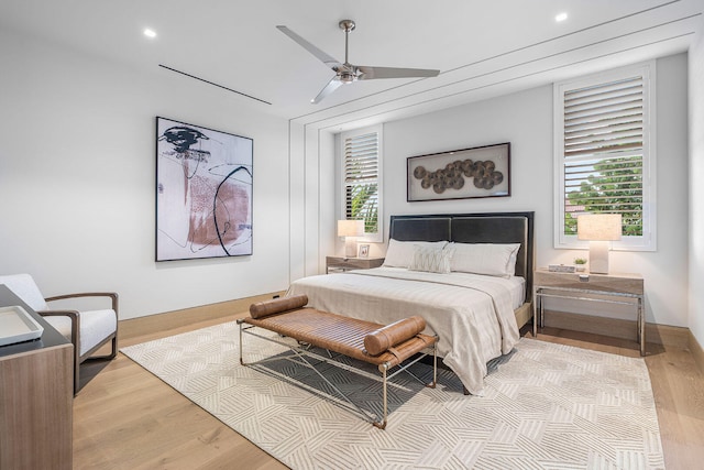 bedroom featuring light wood-type flooring, multiple windows, and ceiling fan