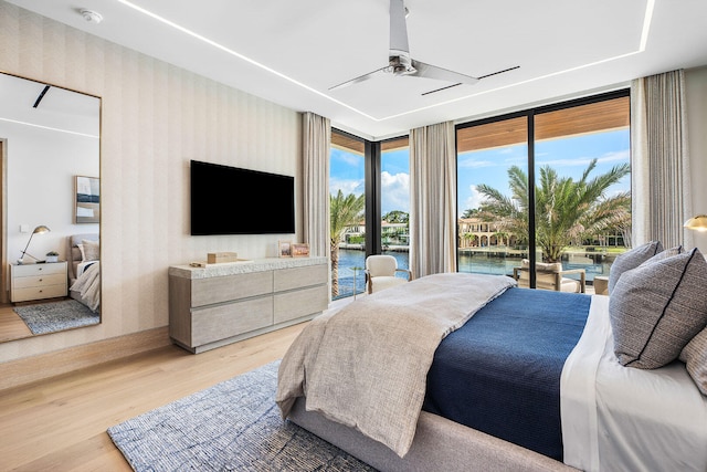 bedroom with access to exterior, light wood-type flooring, and ceiling fan